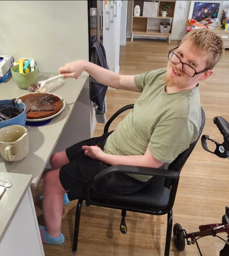 James decorating a chocolate cake in the kitchen