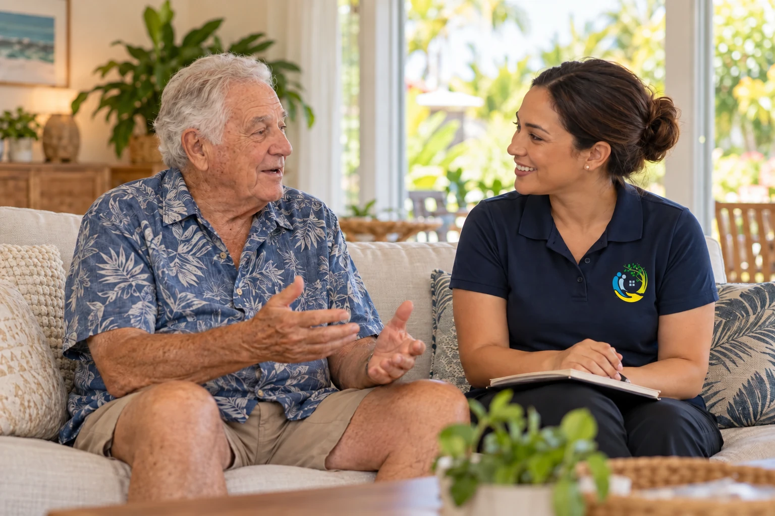 A community nurse in a navy Russell Healthcare polo discussing care with an older adult